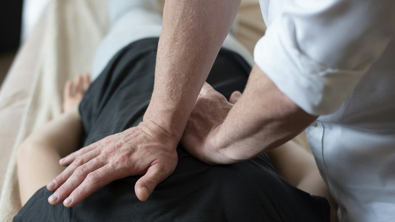 Hands guiding a patient's back during a spinal decompression therapy session